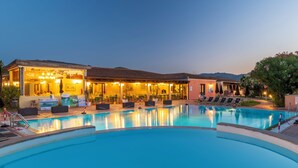 Une piscine avec des chaises longues et un espace bar doté de sièges en plein air.