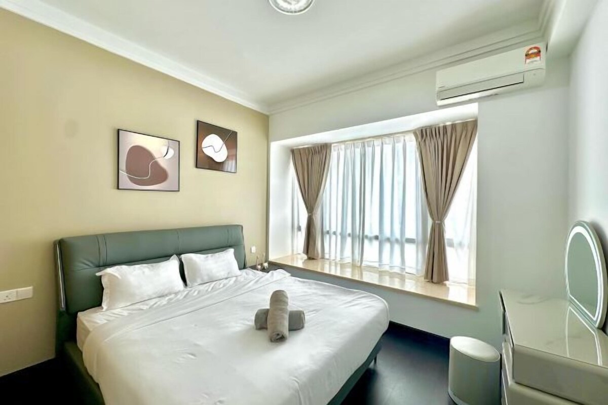 A hotel room with a bed, a window with curtains, a bedside table, and a mirror.