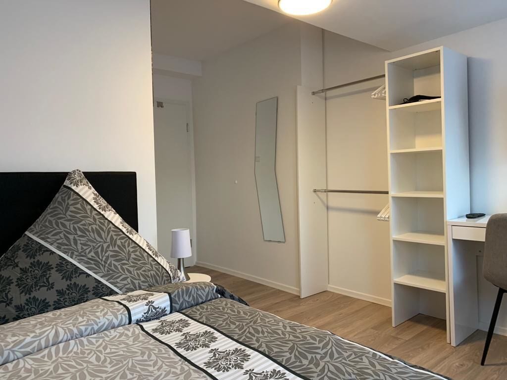 Ein Schlafzimmer mit Bett, Schreibtisch und Kleiderschrank.
