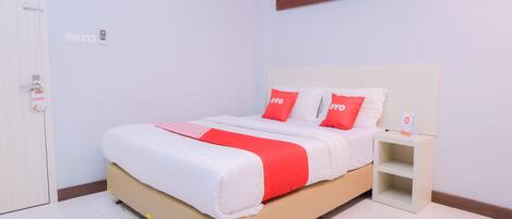 A neatly arranged bedroom with a bed, bedside table, and a wall-mounted artwork.