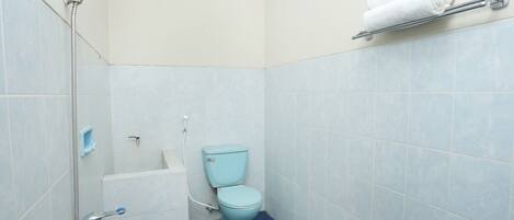 A bathroom with a shower, toilet, and a towel rack.