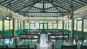 A spacious dining area with high ceilings and large windows, featuring multiple tables and chairs. - Hotel O Penginapan Kepurun Pawana Indonesia (Cangkringan)