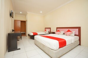 A hotel room with two beds, a desk, and a television. - OYO 2003 Female Guest House (Probolinggo)