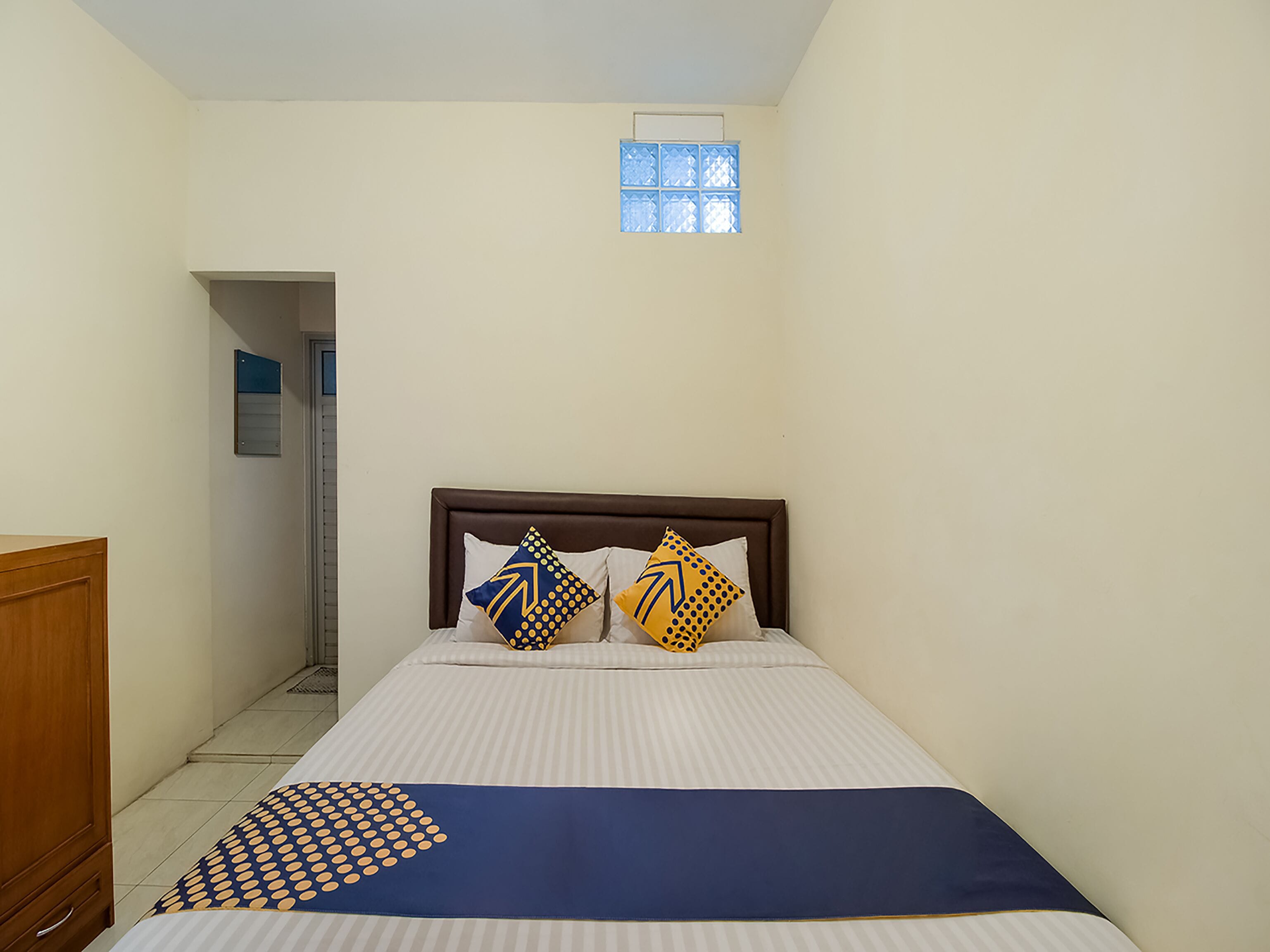 A bedroom with a bed, a window, and a door.