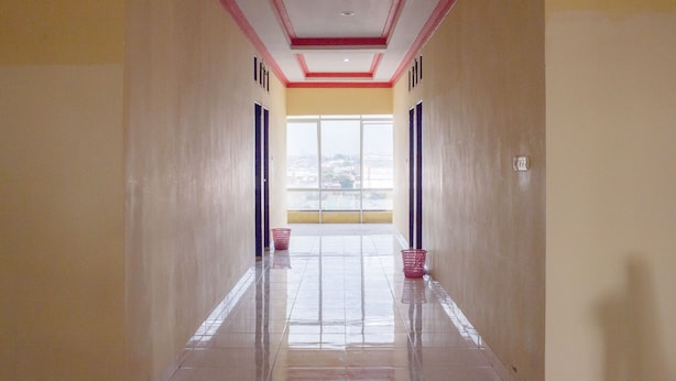 A corridor with a tiled floor and a window at the end. - Hotel O Pondok Bintang (Somba Opu)
