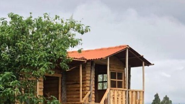 Une cabane en bois dotée d’un balcon et d’un escalier menant à l’étage supérieur.