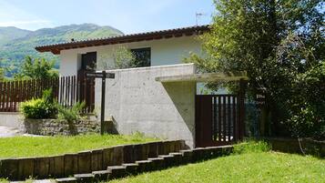 A house with a stone wall, a wooden fence, and a gate.