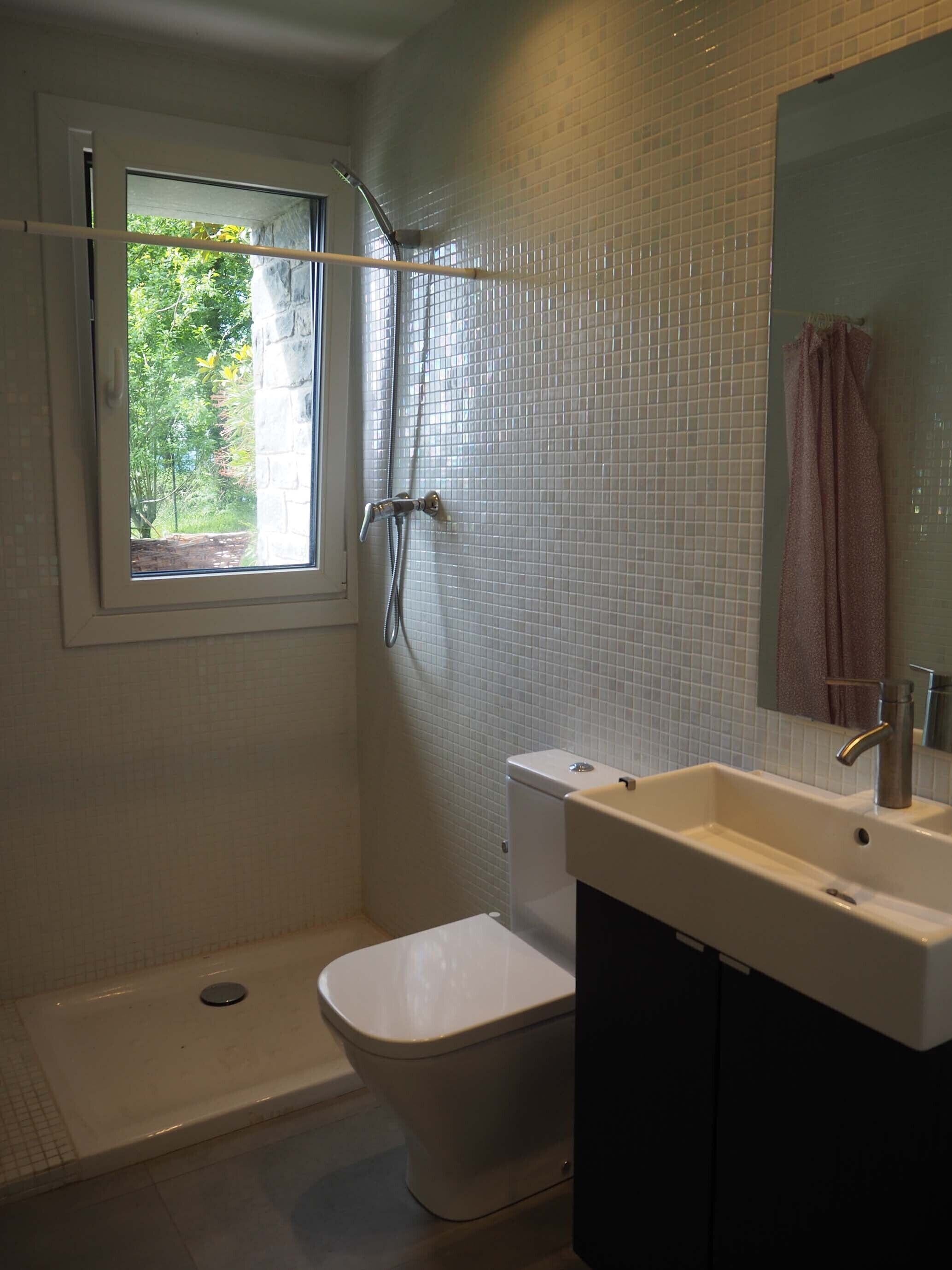 A bathroom with a shower, toilet, and sink.