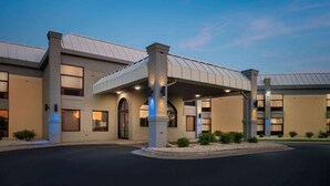 A modern hotel with a covered entrance, brick facade, and multiple windows. - Days Inn & Suites by Wyndham Merrillville (Merrillville)