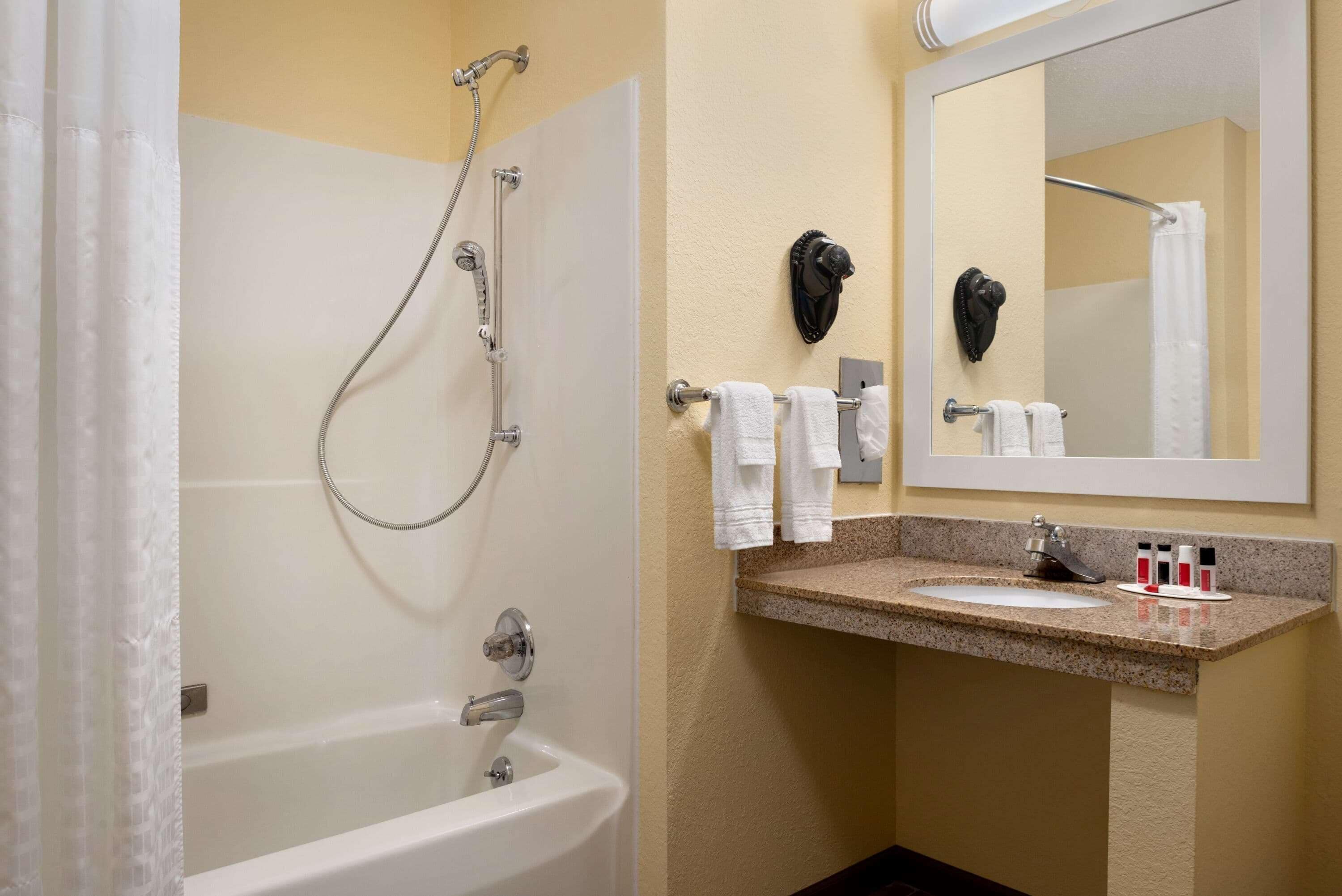 Un baño con bañera, lavamanos y espejo.
