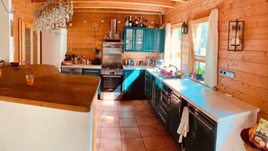 Una cocina amplia con paredes de madera, una isla central y un horno empotrado.