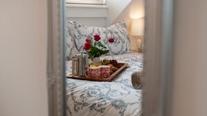 A bedroom with a bed, a tray with breakfast items, and a window with blinds. - Estuary View (Whitby)