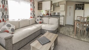 Un salon moderne comprenant un canapé, une table basse et un coin repas avec une table et des chaises.