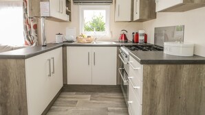 Une cuisine moderne avec des meubles en bois, une cuisinière à gaz et un évier.