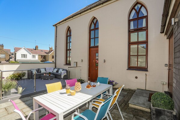 Enjoy dining al fresco on the patio with a sofa and comfortable seating.