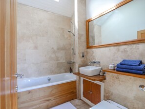 Enjoy a relaxing bath in the spacious bathroom with a bathtub and shower.