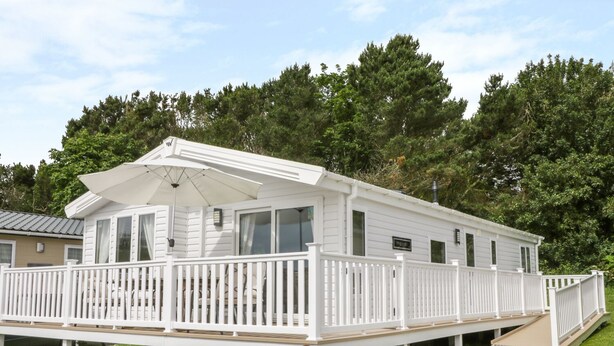 A white mobile home with a balcony and a covered porch area. - Cayton Pines (Scarborough)