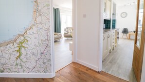 A modern apartment with a large map on the wall, a living room with a sofa, and a kitchen area. - Senafe (Bude)