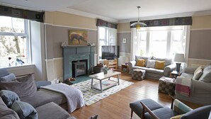 A living room with a fireplace, sofa, and television.