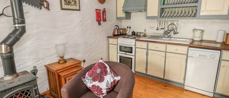 A cozy kitchen with a stove, wooden cabinets, and a sink.
