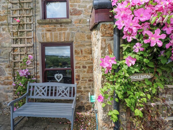 Guests can sit on the bench outside Inglewood's charming entrance, surrounded by a trellis adorned with blooming flowers.