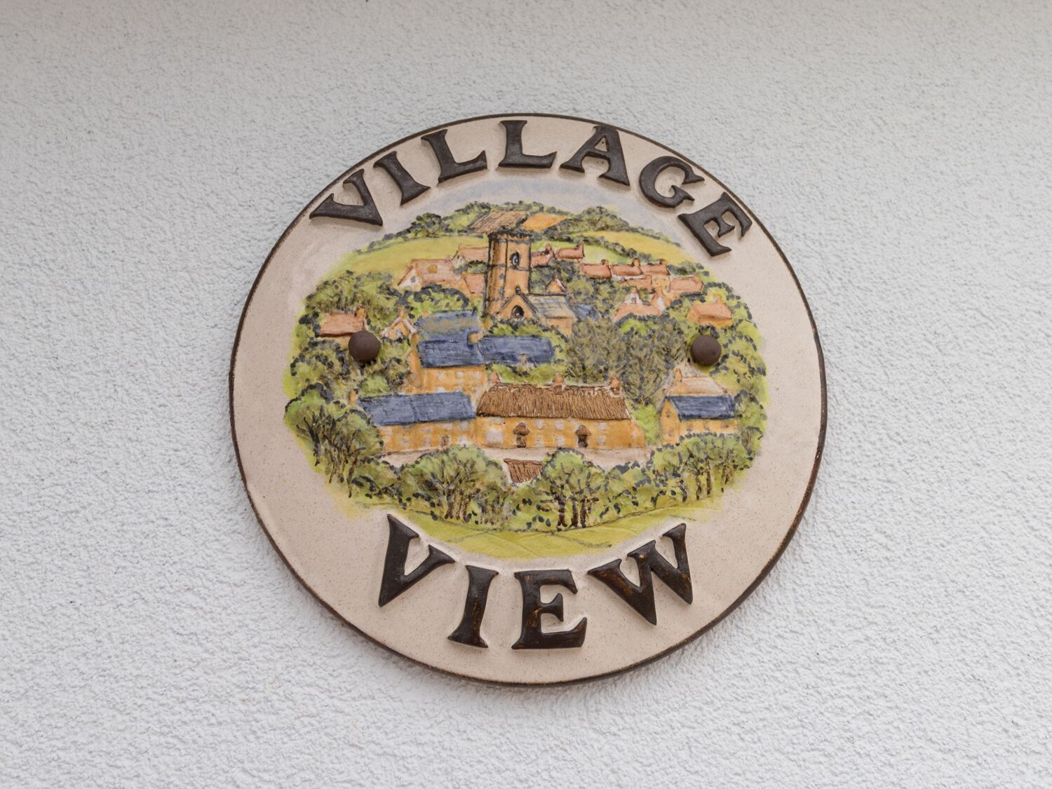A circular sign with a village scene and the words "VILLAGE VIEW" on it.