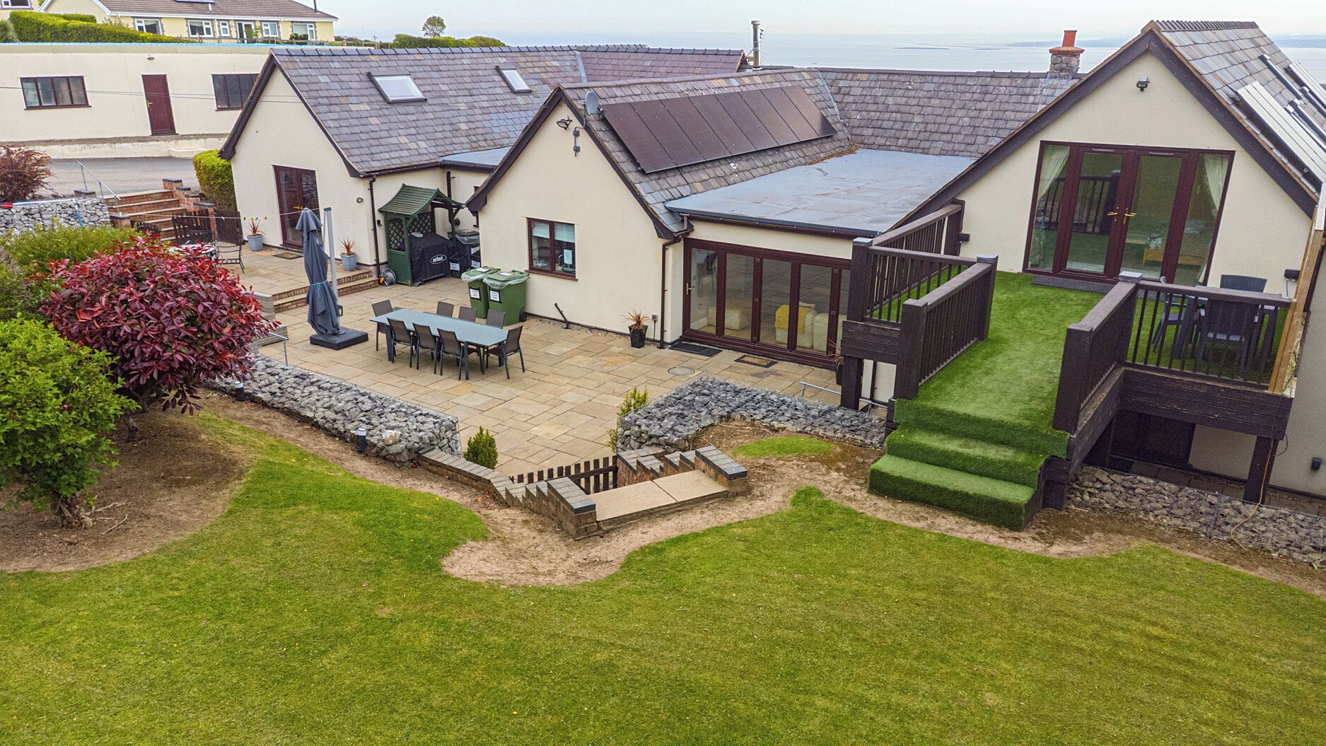 A residential property with a patio, a dining area, and a large window.