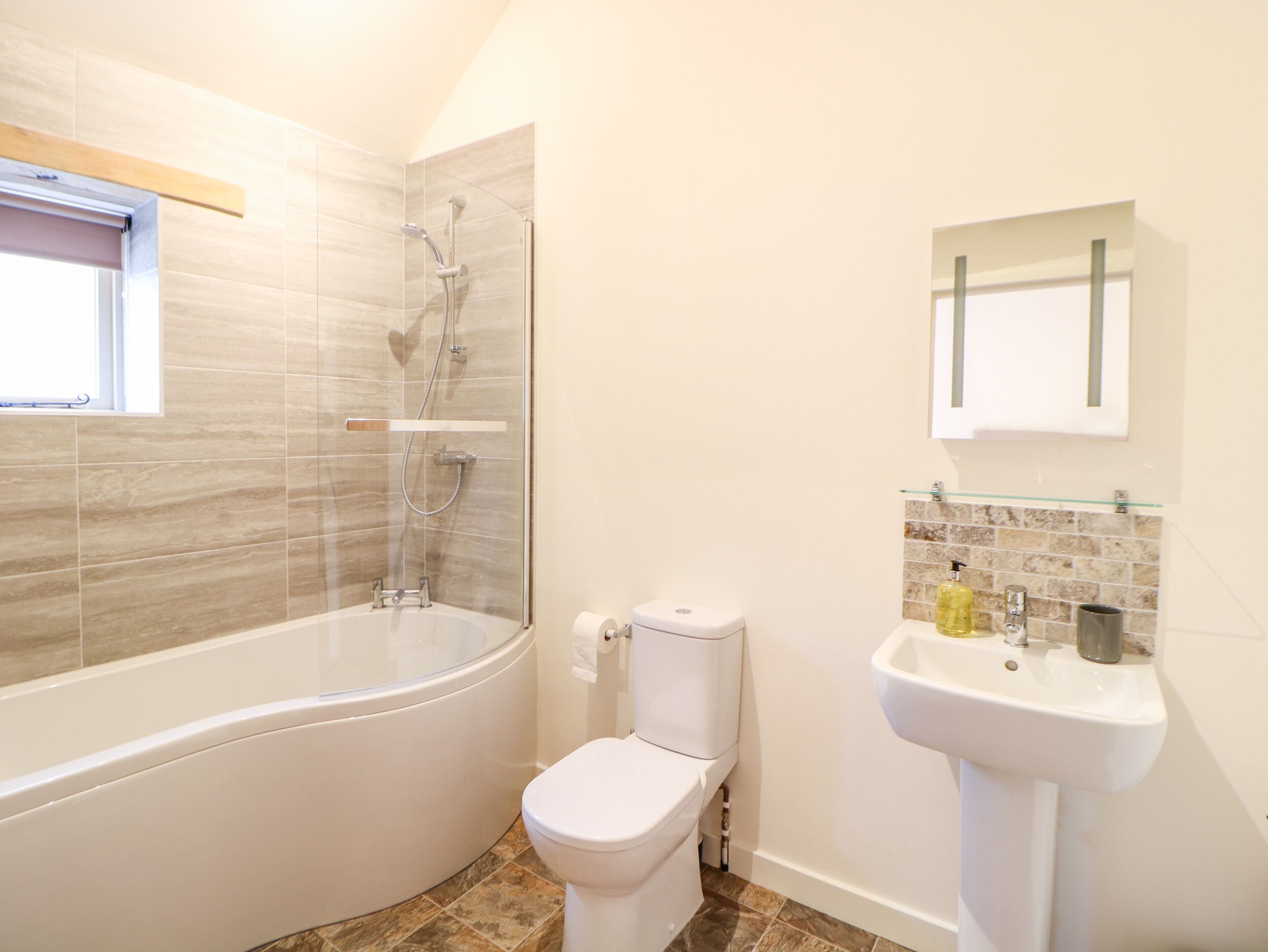 A bathroom with a bathtub, toilet, and sink.