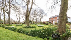 A garden with a sign reading "Willow Grange." - The Stables (Dereham)
