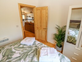 Un dormitorio con cama, planta en maceta y armario de madera.
