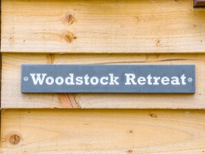 A sign on a wooden wall that reads "Woodstock Retreat." - Woodstock Retreat (Axminster)