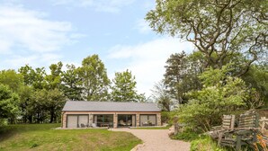 A house with a gravel driveway leading to a covered patio area with outdoor seating. - Coal Drops (Alnwick)