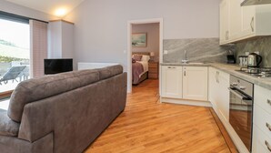 A modern apartment with a living area, kitchen, and bedroom. - Coal Drops (Alnwick)