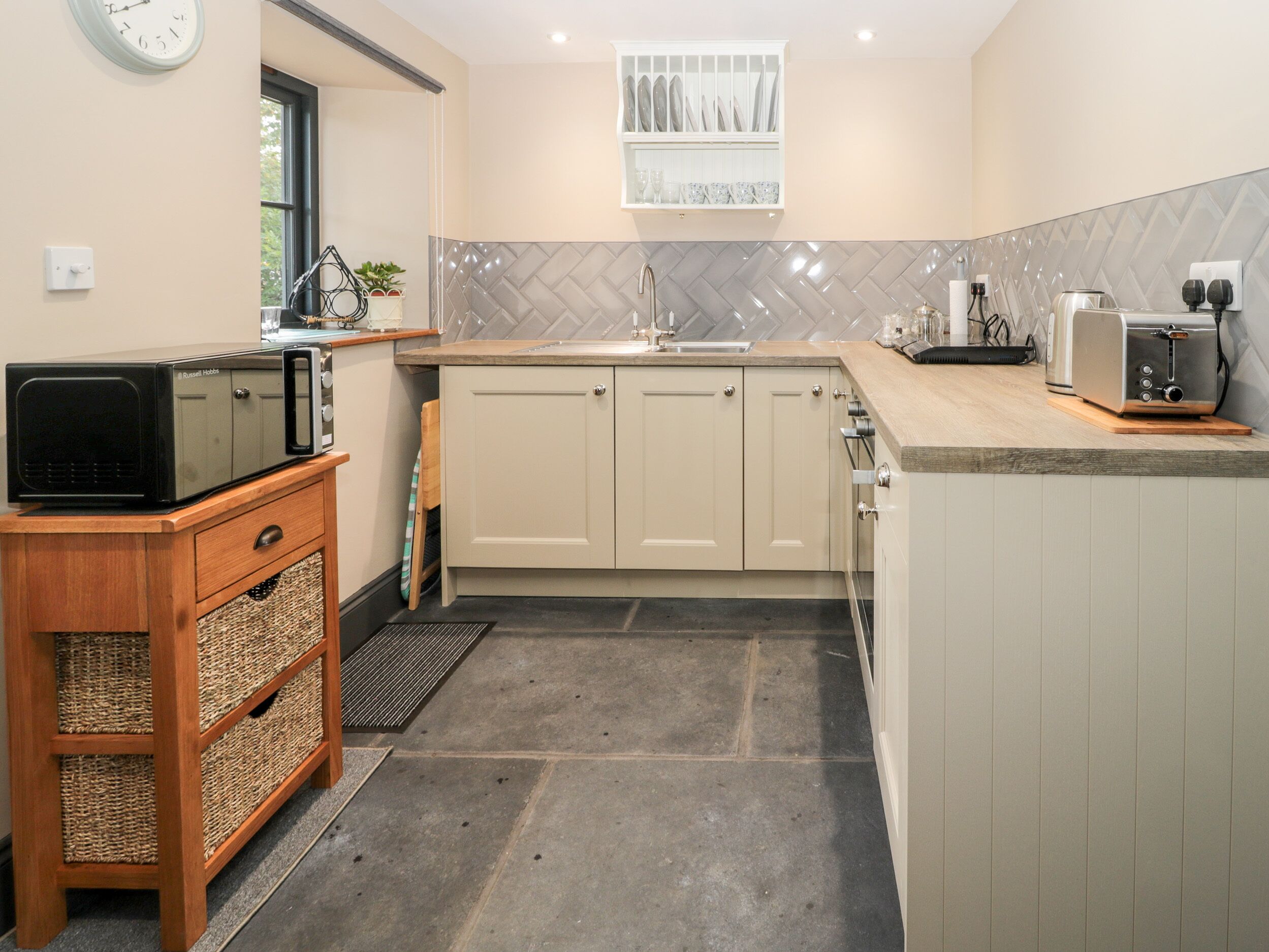 A compact kitchen with a microwave, toaster, and sink.