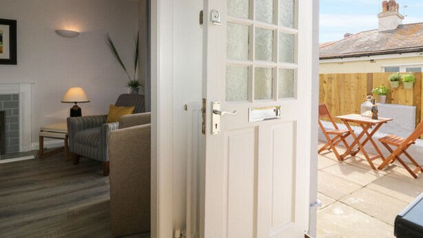 Una sala acogedora con chimenea, un sofá y un comedor con mobiliario de exterior.