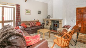 A cozy living room with a fireplace, leather sofas, and a wooden rocking chair. - Felin Iago (Aberystwyth)