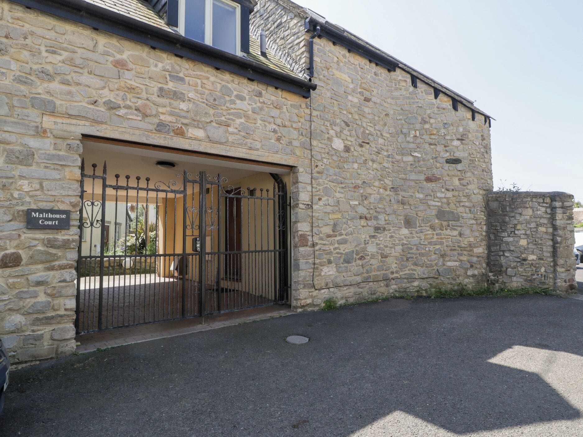 A stone building with a sign reading "Malthouse Court."