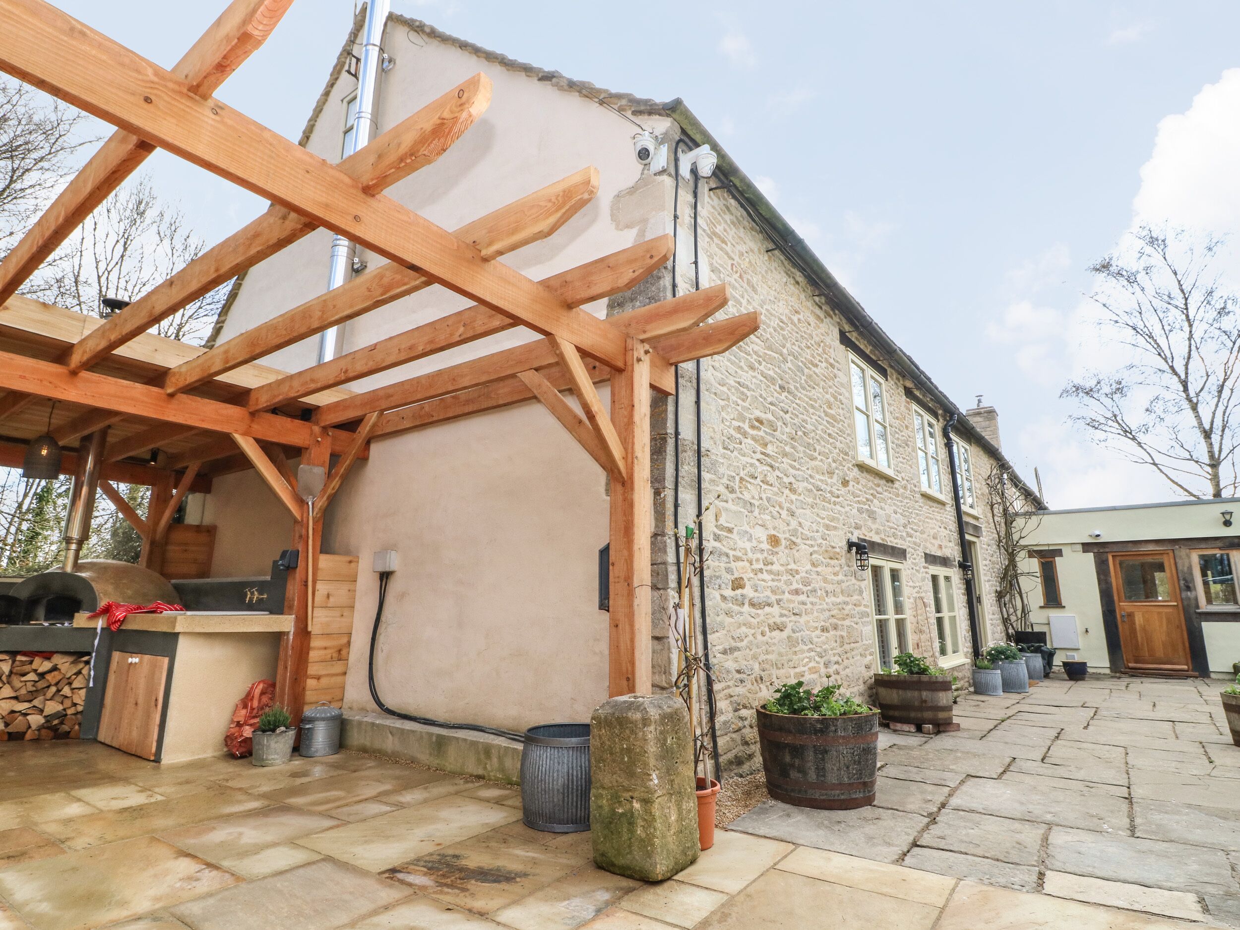 A stone building with a wooden pergola structure.