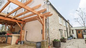 A stone building with a wooden pergola structure.