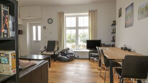 A spacious living area with a wooden floor, a dining table, and a comfortable seating arrangement. - Cherrywood Manor (Bodmin)
