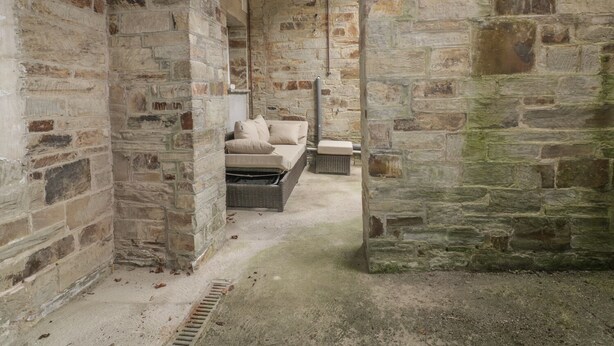 A stone-walled room with a bed, a bench, and a small table. - Cherrywood Manor (Bodmin)