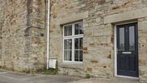 A stone building with a black door and a window. - Cherrywood Manor (Bodmin)