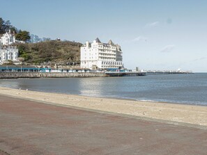 A coastal hotel with a prominent building and a pier extending into the water. - The Nook (Colwyn Bay)