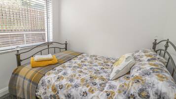 Una camera da letto con un letto, una finestra con persiane e vista sull'esterno.