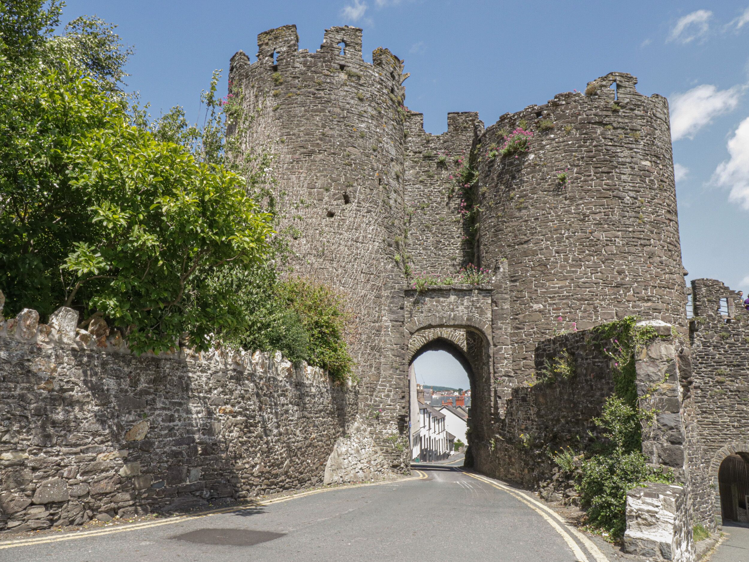Eine historische Steinburg mit einem großen Bogen, der zu einer Stadt führt.