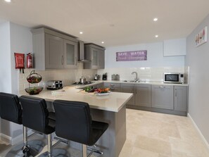 Cottage | Privékeuken | Een vaatwasser, een kinderstoel, kookgerei, borden en bestek