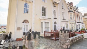 A row of traditional buildings with a mix of architectural styles, including a prominent building with a bay window and a door with a small porch.