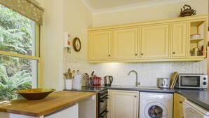 A compact kitchen with a sink, microwave, toaster, and washing machine. - Engine House (Exeter)