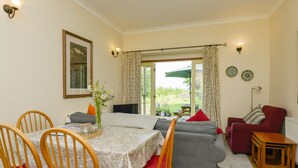 A dining area with a table set for four, a sofa, and a red armchair. - Engine House (Exeter)