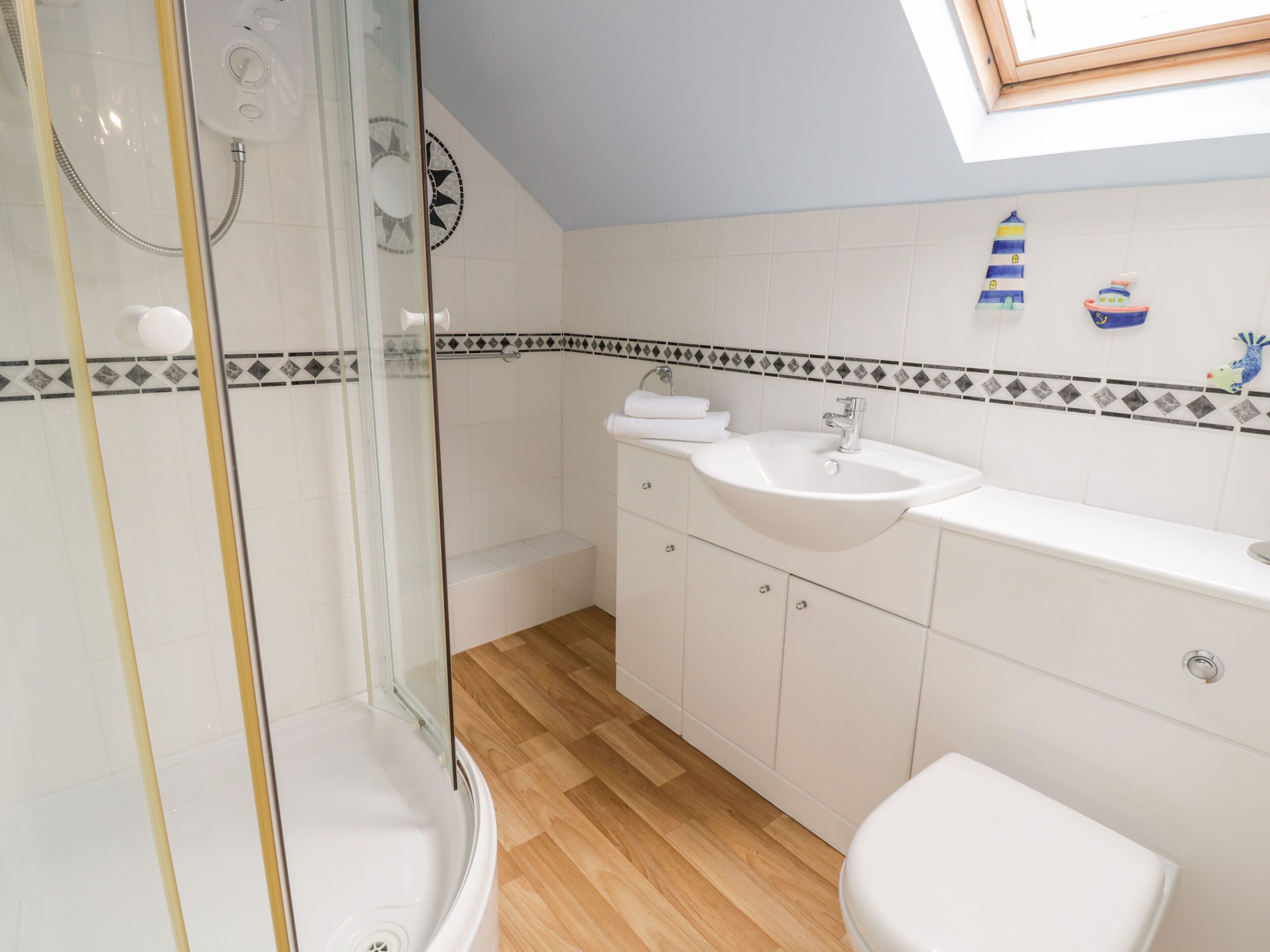 A bathroom with a glass-enclosed shower, a sink, and a toilet.